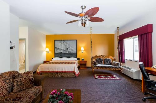 a hotel room with a bed and a couch at Super 8 by Wyndham Salina in Salina