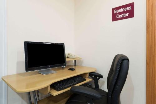 a desk with a computer monitor and a chair at Super 8 by Wyndham Salina in Salina