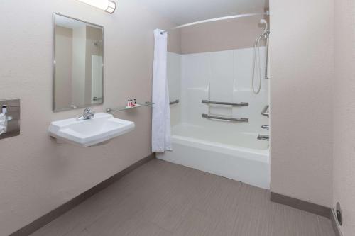 La salle de bains est pourvue d'un lavabo, d'une baignoire et d'une douche. dans l'établissement Baymont by Wyndham Gaylord, à Gaylord