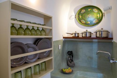 una cocina con botellas verdes y un plato en la pared en Reflection Cave House, en Pirgos
