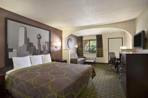 Super 8 by Wyndham Grand Prairie Southwest في غراند براري: غرفة في الفندق مع سرير ومكتب