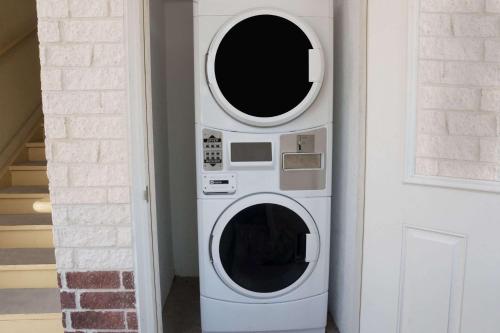 two microwaves in a wall next to a door at Super 8 by Wyndham Rosenberg TX in Rosenberg