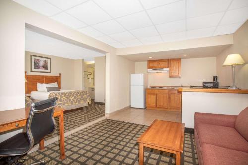 a hotel room with a kitchen and a bed at Baymont by Wyndham Hays in Hays