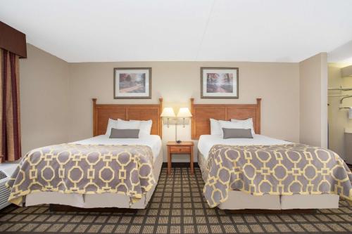 a hotel room with two beds and two lamps at Baymont by Wyndham Hays in Hays
