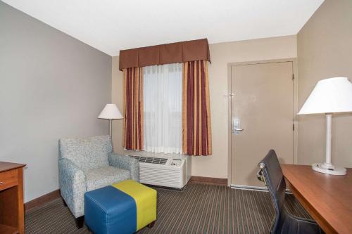 a hotel room with a chair and a desk at Baymont by Wyndham Hays in Hays