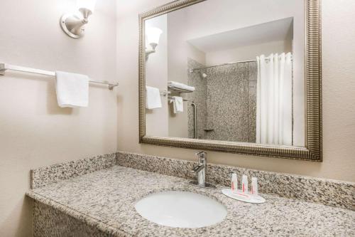 a bathroom with a sink and a mirror at Super 8 by Wyndham Nacogdoches in Nacogdoches