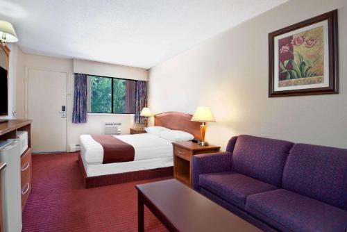um quarto de hotel com uma cama e um sofá em Howard Johnson by Wyndham Red Deer em Red Deer
