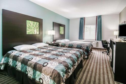 Tempat tidur dalam kamar di Super 8 by Wyndham Brenham TX