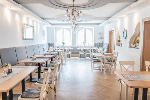 een restaurant met tafels en stoelen en een kroonluchter bij Landhotel Stegersbach in Stegersbach