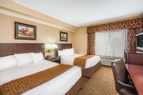 a hotel room with two beds and a television at Hawthorn Suites by Wyndham El Paso in El Paso