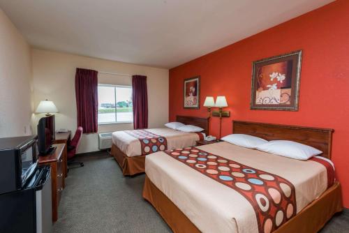 a hotel room with two beds and a flat screen tv at Super 8 by Wyndham St Robert Ft Leonard Wood Area in Saint Robert