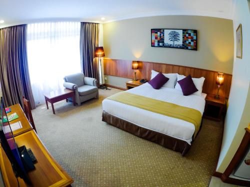 una habitación de hotel con una cama grande y una silla en StarLodge, en Kampong Jerudong