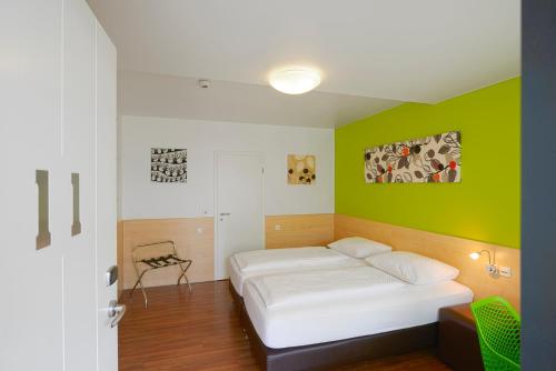 موتيل سيتي سويست في سوست: غرفة نوم بسرير وجدار أخضر