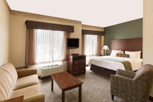 a hotel room with a bed and a tv at Hawthorn Suites by Wyndham Rancho Cordova/Folsom in Rancho Cordova