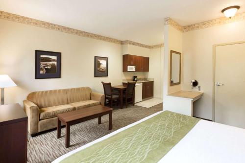 a hotel room with a bed and a couch and a table at Hawthorn Suites by Wyndham Rancho Cordova/Folsom in Rancho Cordova
