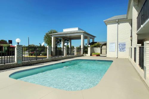 a swimming pool with a gazebo next to a house at Super 8 by Wyndham Lancaster in Lancaster