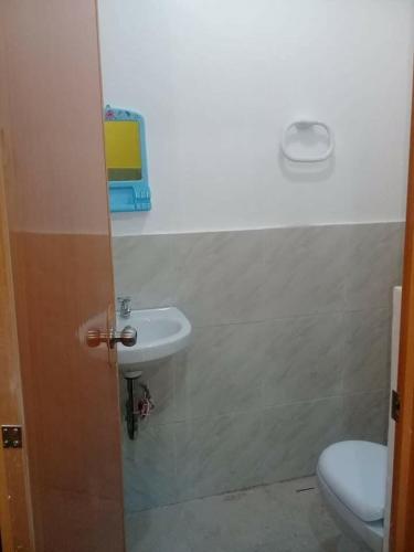 a bathroom with a sink and a toilet at 3Kid's Homestay Yellow in General Luna