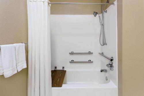 a bathroom with a bath tub with a shower curtain at Super 8 by Wyndham Freeport in Freeport