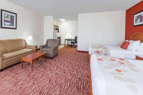 pokój hotelowy z 2 łóżkami, kanapą i krzesłem w obiekcie Hawthorn Suites Irving DFW South w mieście Irving