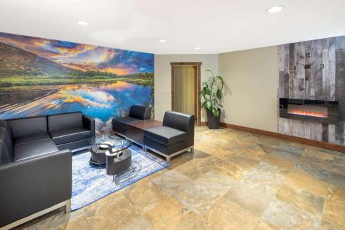 a living room with a large painting on the wall at Travelodge by Wyndham Golden Sportsman Lodge in Golden