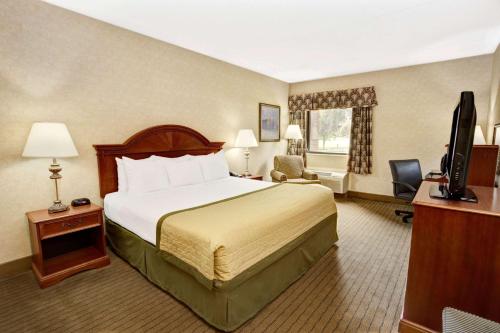 a hotel room with a bed and a television at Baymont by Wyndham Indianapolis West in Indianapolis