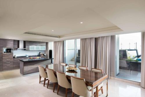 a kitchen and dining room with a table and chairs at Grand Millennium Muscat in Muscat