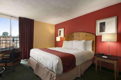 a hotel room with a large bed and a desk at Baymont by Wyndham Salem Roanoke Area in Salem