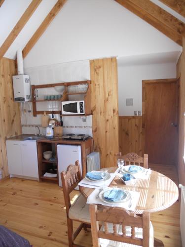 a kitchen and dining room with a table and chairs at L'Emiliano Cabañas-Ristorante in Capitán Pastene