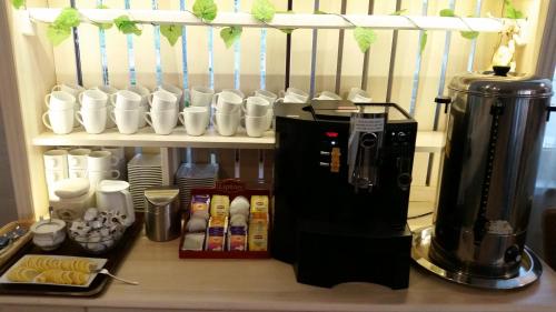 a coffee maker and coffee cups on a counter at OW Krakus I - pokoje i domki in Stegna