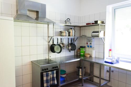 a kitchen with a stove and some pots and pans at Bakterház Vendégház in Nagyvisnyó
