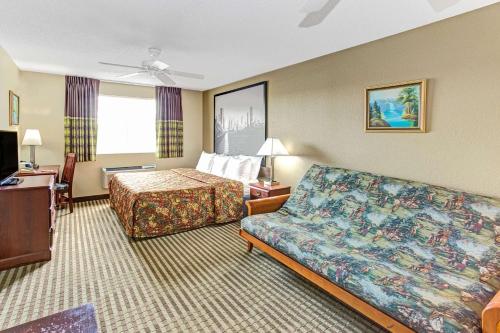 a hotel room with a bed and a couch at Super 8 by Wyndham Gurnee in Gurnee
