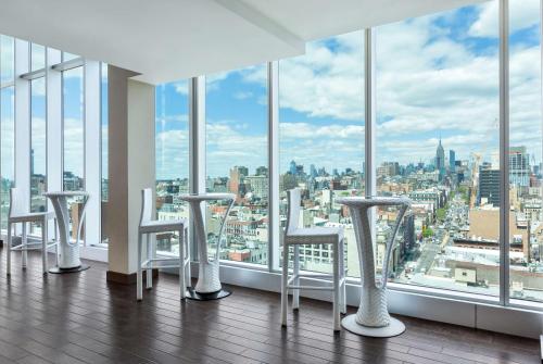 a room with a view of a city with stools at Wyndham Garden Chinatown in New York