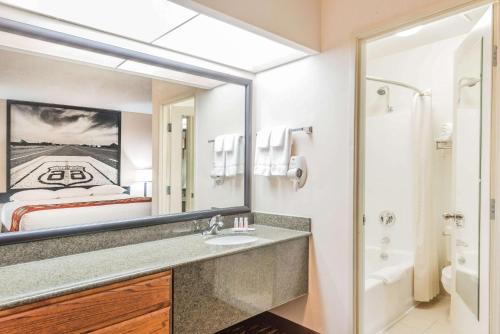 a bathroom with a sink and a large mirror at Super 8 by Wyndham Clovis in Clovis