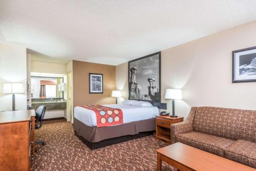 a hotel room with a bed and a couch at Super 8 by Wyndham Clovis in Clovis