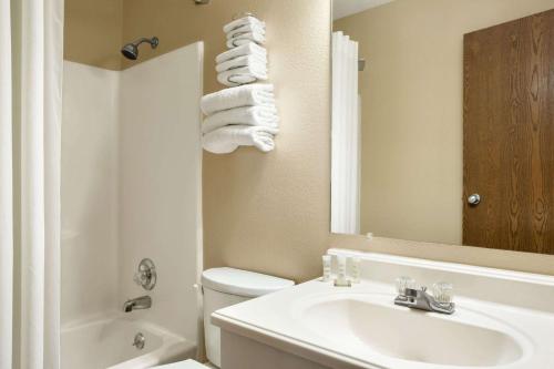 La salle de bains est pourvue d'un lavabo, de toilettes et d'un miroir. dans l'établissement Super 8 by Wyndham Carbondale, à Carbondale