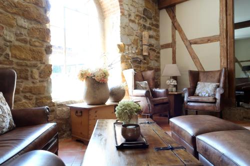 a living room with leather couches and a table at Romantik Hotel am Brühl in Quedlinburg