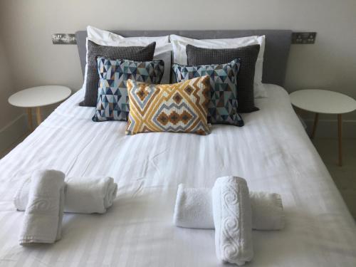 a white bed with pillows and towels on it at Saltwater Suites at Fistral in Newquay