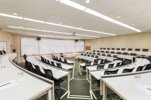 an empty classroom with white tables and black chairs at Ivey Spencer Leadership Centre in London