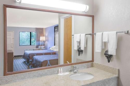 a hotel room with a bathroom with a sink and a mirror at Super 8 by Wyndham Brinkley in Brinkley