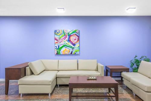 a living room with a couch and a painting on the wall at Super 8 by Wyndham Brinkley in Brinkley