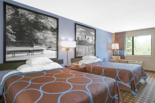 a hotel room with two beds in a room at Super 8 by Wyndham Brinkley in Brinkley