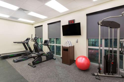 a gym with exercise equipment and a flat screen tv at Wingate by Wyndham Miami Airport in Miami
