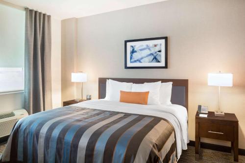 a large bed in a hotel room with two lamps at Wingate by Wyndham Miami Airport in Miami