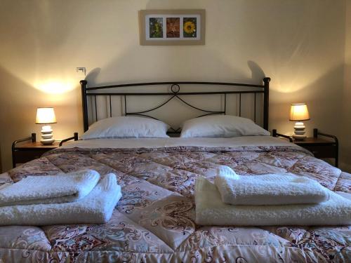 a bedroom with a bed with two pillows and two lamps at Leonidio Climb2red home in Leonidion
