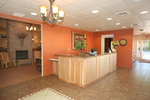 a lobby with orange walls and a reception counter at Trails End Motel Sheridan in Sheridan