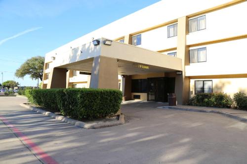 a building with a parking lot in front of it at Baymont by Wyndham Plano in Plano