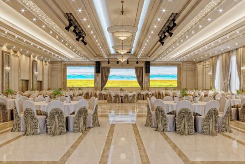 a banquet hall with white tables and chairs at Wyndham Garden Astana in Astana