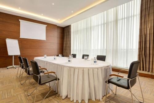 a meeting room with a round table and chairs at Wyndham Garden Astana in Astana