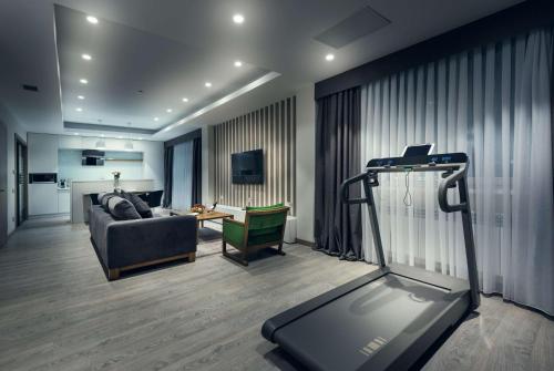 a living room with a couch and a treadmill at Wyndham Garden Astana in Astana