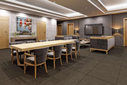 a conference room with a table and chairs and a television at Wyndham Garden Astana in Astana